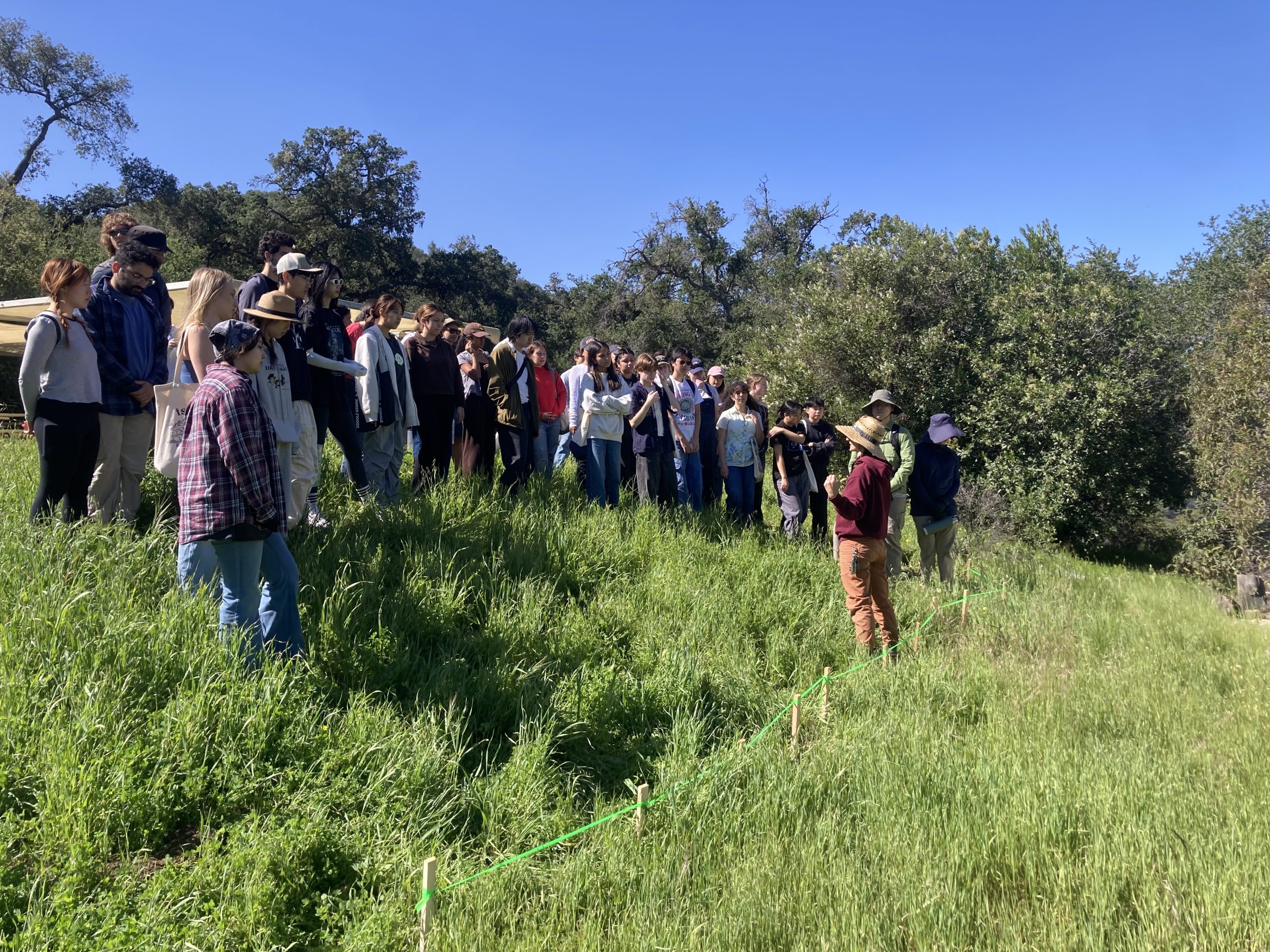 Public facing speaker as they talk in on grassland hillside.